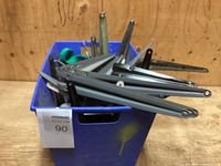 Blue plastic tote containing new metal shelf brackets and assorted hardware.