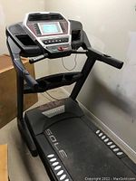 Full view of the SOLE treadmill showing running belt, hand rails and console
