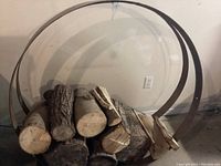 Front view of two rusted metal wagon wheel rims holding firewood logs