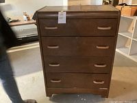 Front view of wooden chest of drawers on castors showing all four drawers and handles.