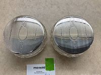 Top view showing pair of crystal dresser jars with polished sterling silver engraved lids featuring a central oval cartouche area and decorative engraving on lids.