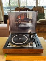 Front view of Dual 12 28 turntable with dust cover open showing platter and tonearm