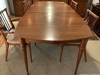 Front view of the table fully extended with leaves inserted, showing overall length and seating capacity.