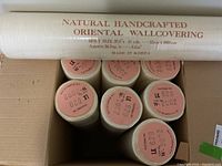 Top view showing all seven rolls in box with pink labels on ends indicating pattern and lot numbers.