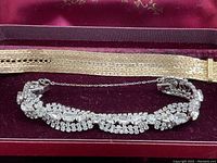 Close-up photo of the rhinestone bracelet and gold plated buckle bracelet inside the velvet-lined jewelry box.