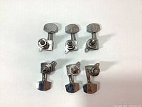 Top view of six chrome guitar tuning pegs machine heads arranged in two rows of three.