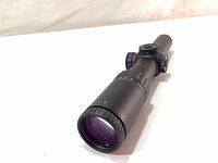 Side angle showing multi-coated lens and adjustment dials on the scope body.