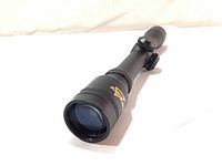 Front angled view of Excalibur crossbow scope showing gold logo on black body and lens.