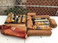 Photo showing assortment of fire logs, including wrapped Mastercraft and Johnson Fireside fire logs and unwrapped pellet style fire logs.