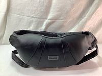 Front view of the HoMEDICS neck and shoulder massager showing black synthetic leather exterior with brand label.