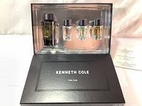 Full view of the Kenneth Cole gift set box opened showing large and three small Eau De Toilette spray bottles set inside a plastic tray with black box base.