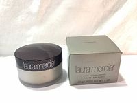 Photo showing Laura Mercier loose setting powder container with lid and original box beside it, showcasing the product and packaging.