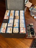 Overall view of 24 AIREQUIPT slide boxes arranged in case with wooden tray of mounted slides at right