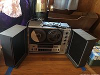 Craig 2402 reel to reel tape recorder with two large reels, face controls, and two separate speakers open and displayed.