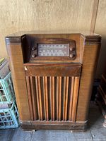 Full view of Philco vintage wooden console radio showing the front grille and overall cabinet condition.