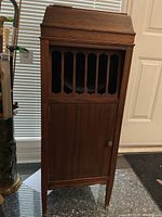 Full height front view of oak-finish wooden cabinet