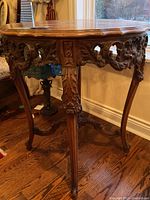 Full view of oval table showing carved skirt, legs and top surface