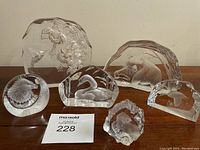 Front view of all six glass sculptures arranged on a table