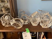 Wide shot of all seven crystal sculptures displayed on wooden surface