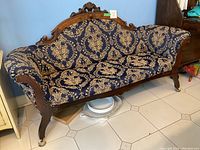 Front view of entire settee showing carved walnut frame and damask upholstery