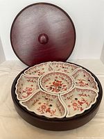Closed wooden lid showing smooth reddish wood finish and knob handle.