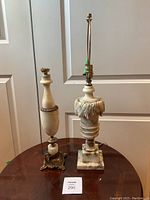 Full view showing two lamps, one with carved leaf design, one with smooth alabaster body and brass base.