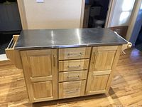 Front view showing two cabinet doors and four drawers under stainless steel top