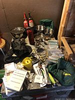 Full lot overview showing cookware, fire extinguishers, cooking pots, bowls, assorted gear, and documents.