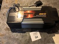 Top view of power inverter showing 'Eliminator 1500 W Digital Power Inverter' label with attached power cable and switch.