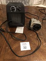 Black portable heater fan viewed from front showing control knobs and mesh grille