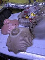 Close-up of three glass light shades and part of electrical wiring and mounting chain.