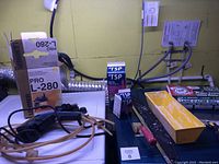 Wide view on a surface with painting supplies including TSP steel wool, Bull Dog steel wool, yellow mixing tray, scrapers, clamps, and packaging