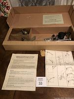 Photo depicting the drafting machine components inside an open cardboard box with instruction sheets included.