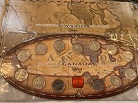Original sealed packaging showing 15 Canadian Millennium quarters arranged in oval plastic case with Canada map background dated 1999.