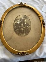 Full view of the antique oval frame with a black and white photograph of four generations inside