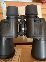 Top angle view of black Bushnell 10x50 binoculars showing eyepieces and textured grips.