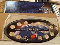 Oval set showing 15 Canada 2000 millennium quarters in original display packaging with Earth and space background and bilingual text.