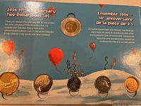 Photo showing the 2006 two-dollar coin set in commemorative collector card with all six coins arranged in slots and bilingual text describing the set on a blue background with celebratory balloons.