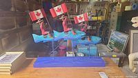 Front view of full sculpture showing two RCMP figures on fish with Canadian flags