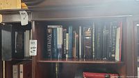 Photo of wooden bookshelf with 17 history books, both hard and soft covers, titles visible including Napoleon and Blood Royal.