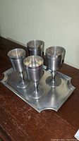 Four John Somers pewter goblets arranged on the pewter tray, showing height and general shape.