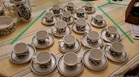 Eighteen pieces of Portmeirion cups with saucers including large and small cups and creamers arranged on a table.
