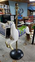 Front right three-quarter view of white carousel horse showing painted details, saddle and pole attachment