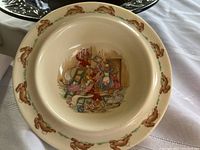 Top view of the ceramic bowl showing the bunny wallpapering scene and bunny border on the rim.