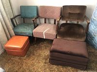 Three vintage wooden chairs and two footstools arranged side by side against a wall, showing upholstery and frame condition