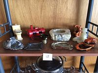 Full view of all 10 ashtrays arranged on wooden stock shelf, showcasing various materials and styles.