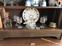Full display showing crystal decanter, six matching glasses, decorative collectible plate, glass coasters in holder, and ornate coaster box.