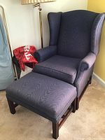 Wide view of Pennsylvania House wingback chair and ottoman set showing upholstery and wooden legs.