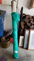 Rolled Threshold outdoor rug wrapped in green packaging with label visible, standing in garage.