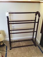 Front view of the wood quilt rack showing three horizontal bars and rectangular base